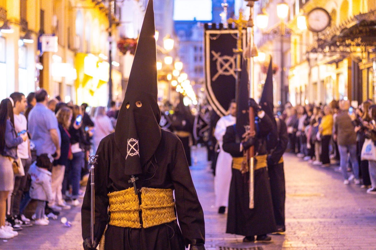 folla in una piazza spagnola con simboli religiosi