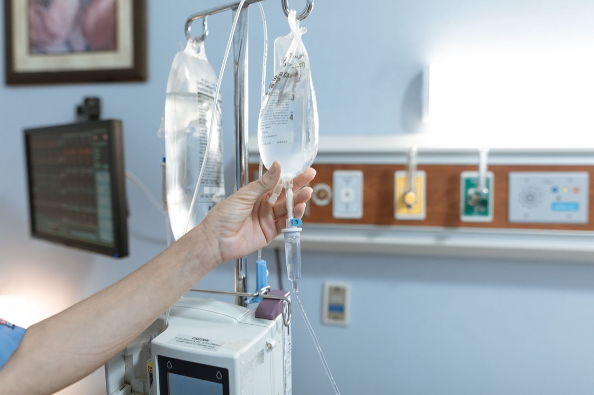 Una nurse spagnola con un paziente in una stanza d'ospedale